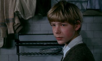 Movie still from “Our Mother's House” (1967), directed by Jack Clayton – A young boy with blonde hair and a sweater; Close Up shot, Low angle