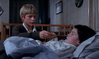 Movie still from “Our Mother's House” (1967), directed by Jack Clayton – A young boy feeding something to a young girl in a bed; Medium shot, High angle