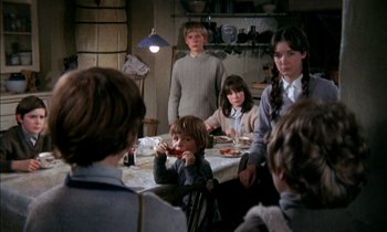 Movie still from “Our Mother's House” (1967), directed by Jack Clayton – A group of people sitting around a table eating food; Medium shot, High angle