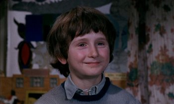 Movie still from “Our Mother's House” (1967), directed by Jack Clayton – A young boy smiling for the camera in front of a wall; Close Up shot, High angle