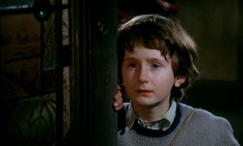 Movie still from “Our Mother's House” (1967), directed by Jack Clayton – A young boy is standing next to a metal pole; Close Up shot, High angle