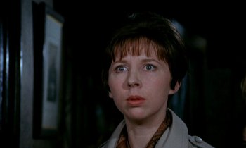 Movie still from “Our Mother's House” (1967), directed by Jack Clayton – A woman with short brown hair wearing a trench coat; Close Up shot, Low angle