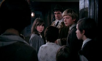 Movie still from “Our Mother's House” (1967), directed by Jack Clayton – A group of people standing around each other in a room; Medium shot, Over the shoulder angle