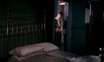 Movie still from “Our Mother's House” (1967), directed by Jack Clayton – A man standing in front of a bed in a room; Wide shot, High angle