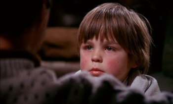 Movie still from “Our Mother's House” (1967), directed by Jack Clayton – A young boy sitting in front of a person; Close Up shot, High angle