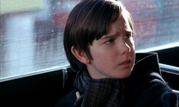Movie still from “Our Mother's House” (1967), directed by Jack Clayton – A young boy sitting in the back seat of a car; Close Up shot, Low angle