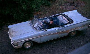 Movie still from “Our Mother's House” (1967), directed by Jack Clayton – A man sitting in the back seat of an old blue car; Wide shot, High angle