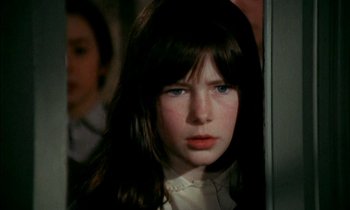Movie still from “Our Mother's House” (1967), directed by Jack Clayton – A young girl with long brown hair wearing a white shirt; Close Up shot, High angle