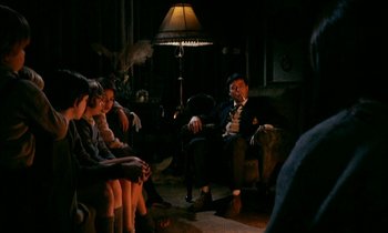 Movie still from “Our Mother's House” (1967), directed by Jack Clayton – A group of people sitting in a living room; Wide shot, Over the shoulder angle
