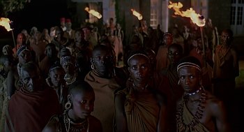 Movie still from “Out of Africa” (1985), directed by Sydney Pollack – A large group of people standing in a room; Medium shot, High angle