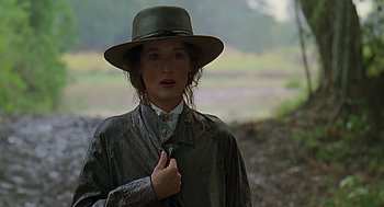 Movie still from “Out of Africa” (1985), directed by Sydney Pollack – A woman wearing a hat and a jacket; Close Up shot, Over the shoulder angle