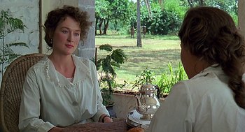 Movie still from “Out of Africa” (1985), directed by Sydney Pollack – Two people sitting at a table in front of a tea pot; Medium shot, Over the shoulder angle