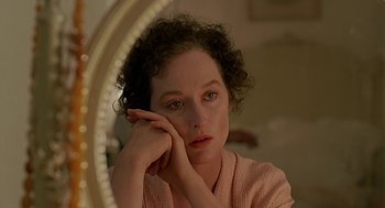 Movie still from “Out of Africa” (1985), directed by Sydney Pollack – A woman is sitting in front of a round mirror; Close Up shot, High angle