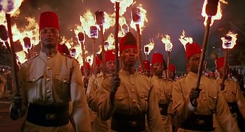 Movie still from “Out of Africa” (1985), directed by Sydney Pollack – A group of men in military uniforms holding torches; Medium shot, High angle