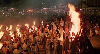 Movie still from “Out of Africa” (1985), directed by Sydney Pollack – A group of people in military garb are holding torches; Extreme Wide shot, High angle