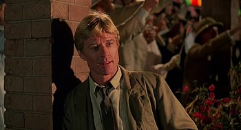 Movie still from “Out of Africa” (1985), directed by Sydney Pollack – A person wearing a suit and tie; Close Up shot, Over the shoulder angle