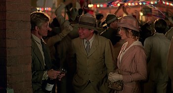 Movie still from “Out of Africa” (1985), directed by Sydney Pollack – A group of people standing next to each other in a room; Medium shot, Over the shoulder angle