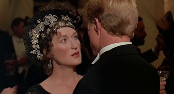 Movie still from “Out of Africa” (1985), directed by Sydney Pollack – A man and a woman in formal wear looking at one another; Close Up shot, Over the shoulder angle