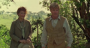 Movie still from “Out of Africa” (1985), directed by Sydney Pollack – A man and a woman standing next to each other in a field; Medium shot, Over the shoulder angle