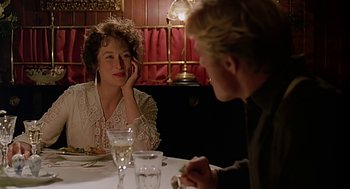 Movie still from “Out of Africa” (1985), directed by Sydney Pollack – Two people sitting at a table in front of each other at a restaurant; Close Up shot, Over the shoulder angle
