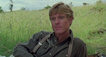 Movie still from “Out of Africa” (1985), directed by Sydney Pollack – A person in a grassy field; Close Up shot, Low angle
