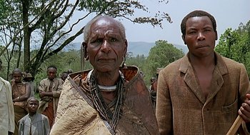 Movie still from “Out of Africa” (1985), directed by Sydney Pollack – Two people standing next to each other near a forest; Close Up shot, Low angle