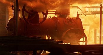 Movie still from “Out of Africa” (1985), directed by Sydney Pollack – An old steam engine is burning in the dark; Extreme Wide shot, Low angle