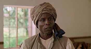 Movie still from “Out of Africa” (1985), directed by Sydney Pollack – An older man wearing a head scarf and a vest; Close Up shot, Low angle