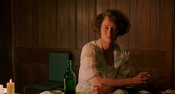 Movie still from “Out of Africa” (1985), directed by Sydney Pollack – A woman sitting in front of a green bottle; Close Up shot, Low angle