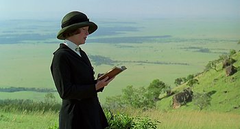 Movie still from “Out of Africa” (1985), directed by Sydney Pollack – A woman standing on top of a grass covered hill; Medium shot, Low angle