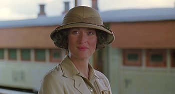 Movie still from “Out of Africa” (1985), directed by Sydney Pollack – A woman wearing a tan hat and a tan jacket; Close Up shot, Low angle