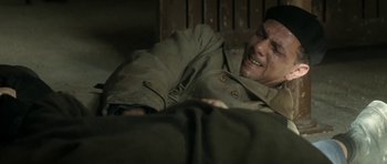 Movie still from “Outside the Law” (2010), directed by Rachid Bouchareb – A man laying on the ground with his head on his chest; Close Up shot, High angle