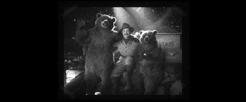 Movie still from “Paddington” (2014), directed by Paul King – A black and white photo of a man and two stuffed bears; Wide shot, Low angle