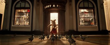 Movie still from “Paddington” (2014), directed by Paul King – A teddy bear that is standing in front of a flock of pigeons; Wide shot, Low angle