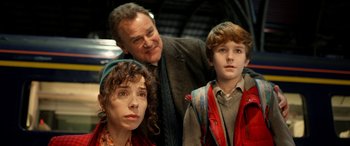 Movie still from “Paddington” (2014), directed by Paul King – A man and a woman standing next to a young boy; Medium shot, Low angle