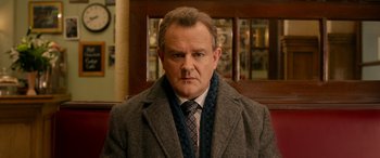 Movie still from “Paddington” (2014), directed by Paul King – A person wearing a coat and tie; Close Up shot, Low angle