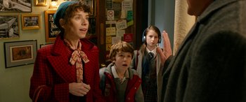 Movie still from “Paddington” (2014), directed by Paul King – A group of people standing next to each other in a room; Medium shot, Over the shoulder angle