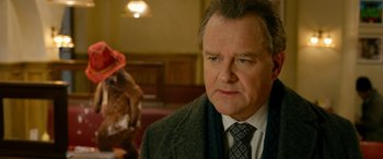 Movie still from “Paddington” (2014), directed by Paul King – A man in a suit and tie looking to his left; Close Up shot, Over the shoulder angle