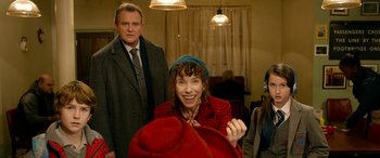 Movie still from “Paddington” (2014), directed by Paul King – A man and a woman standing next to each other in a room; Medium shot, Over the shoulder angle