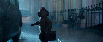 Movie still from “Paddington” (2014), directed by Paul King – A dog in the rain holding a briefcase; Wide shot, Low angle
