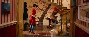 Movie still from “Paddington” (2014), directed by Paul King – A woman in a red dress standing in front of a bear; Wide shot, Over the shoulder angle