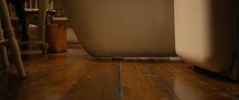 Movie still from “Paddington” (2014), directed by Paul King – View of a wooden floor with a laptop; Extreme Close Up shot, Overhead angle