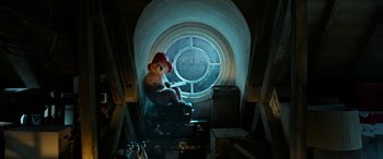 Movie still from “Paddington” (2014), directed by Paul King – A teddy bear sitting in front of a round window; Wide shot, Overhead angle