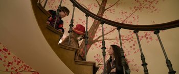 Movie still from “Paddington” (2014), directed by Paul King – Two people and a dog on a spiral stair case; Medium shot, Low angle