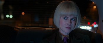 Movie still from “Paddington” (2014), directed by Paul King – A woman sitting in a car wearing a purple tie; Close Up shot, Over the shoulder angle