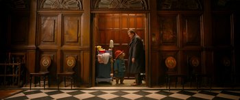 Movie still from “Paddington” (2014), directed by Paul King – A man and a child standing in front of an open door; Medium shot, Over the shoulder angle