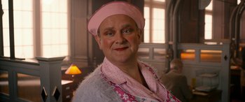 Movie still from “Paddington” (2014), directed by Paul King – An older man wearing a pink hat and a pink shirt; Close Up shot, Over the shoulder angle