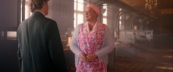 Movie still from “Paddington” (2014), directed by Paul King – An older woman wearing a pink apron and a pink hat; Medium shot, Over the shoulder angle