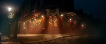 Movie still from “Paddington” (2014), directed by Paul King – A building that is lit up at night time; Wide shot, Low angle