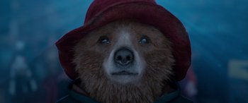 Movie still from “Paddington” (2014), directed by Paul King – A brown teddy bear wearing a red hat; Close Up shot, Low angle